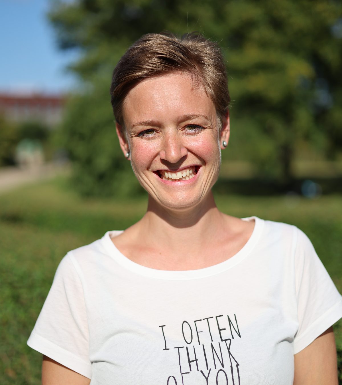 Melanie Platz lächelt in die Kamera, im Hintergrund ein sonniger Park